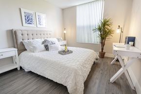 Tamarac apartment for rent - A bedroom with a large bed and a plant.