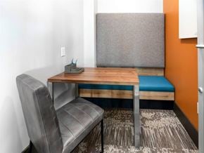 Orlando apartment for rent - A grey chair sits in front of a desk with a blue cushion on it.