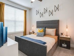 Orlando apartment for rent - A bedroom with a bed, nightstand, and wall decor.