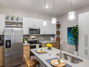 Orlando apartment for rent - A modern kitchen with a stainless steel refrigerator and a wooden cutting board on the counter.