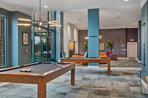 Camp Springs apartment for rent - A pool table is in the middle of a room with a blue column and a couch.