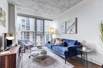 Chicago apartment for rent - A living room with a blue couch and a glass coffee table.