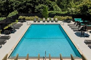 Salem apartment for rent - A large outdoor swimming pool surrounded by lounge chairs and umbrellas.