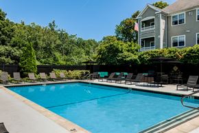 Salem apartment for rent - A large swimming pool with lounge chairs and a building in the background.