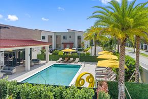 Oakland Park apartment for rent - a swimming pool in front of a hotel with palm trees