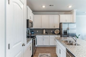 Pooler apartment for rent - A kitchen with white cabinets and granite countertops.