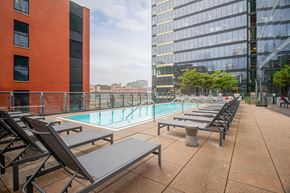 Chicago apartment for rent - A pool area with sun loungers and a tall building in the background.
