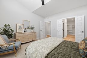 Lee's Summit apartment for rent - A bedroom with a bed, chair, and a dresser with a mirror.