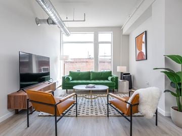 Poughkeepsie apartment for rent - A living room with a green couch and a television.