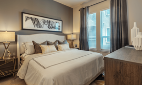 Richardson apartment for rent - A bedroom with a large bed and a painting above it.