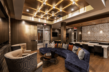 Richardson apartment for rent - A modern living room with a blue couch and a patterned armchair.