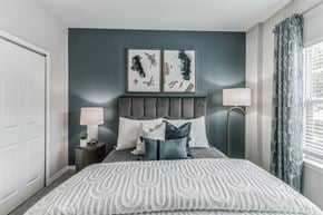 Saraland apartment for rent - A bedroom with a large bed and two lamps.