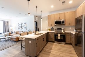 Carmel apartment for rent - 2-Bedroom Apartments in North Indianapolis, IN - North End Apartments - Contemporary Kitchen With Quartz Island, Pendant Lighting, Light Wood Cabinets, and Stainless Steel Appliances.