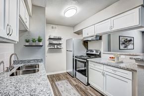 Houston apartment for rent - a kitchen with white cabinets and stainless steel appliances