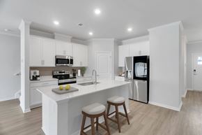 Savannah apartment for rent - A kitchen with white cabinets and a white island with two stools.