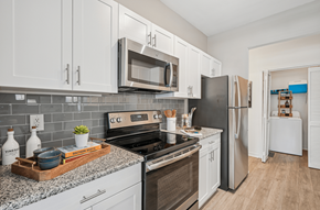 Durham apartment for rent - A kitchen with white cabinets and a black refrigerator.
