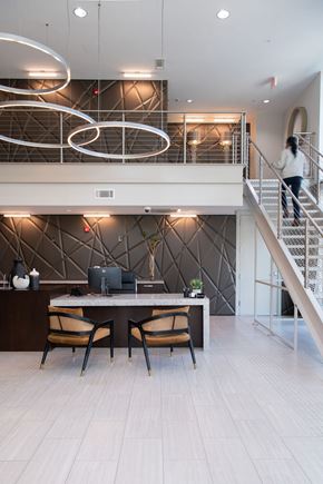 Charlotte apartment for rent - A woman is walking up a staircase in a modern home.