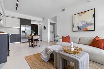 Miami Gardens apartment for rent - A modern living room with a grey sofa and a woven coffee table.
