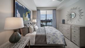 Orlando apartment for rent - A bedroom with a large bed, a bench, and a painting on the wall.