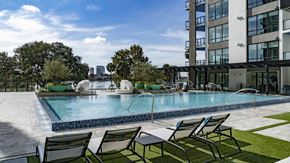 Orlando apartment for rent - a swimming pool in front of a building with a city in the background