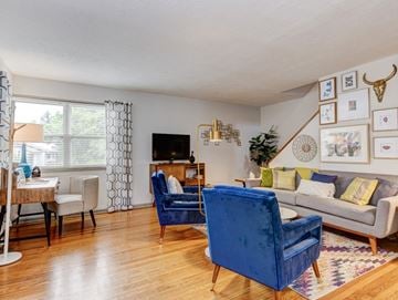 Asheville apartment for rent - A living room with a blue chair and a grey couch.