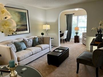 Roanoke apartment for rent - A living room with a white couch, a coffee table, and a painting on the wall.