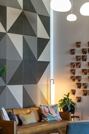 Minneapolis apartment for rent - A living room with a brown couch and a geometric wall mural.