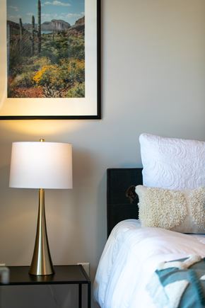 Minneapolis apartment for rent - A bedroom with a bed, a lamp, and a painting on the wall.