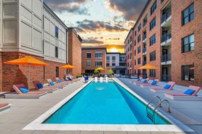 Charleston apartment for rent - a swimming pool in the middle of a building with orange umbrellas