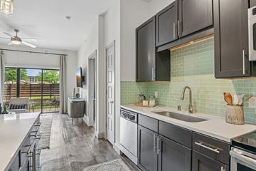 Plano apartment for rent - A modern kitchen with dark wood cabinets and a white countertop.