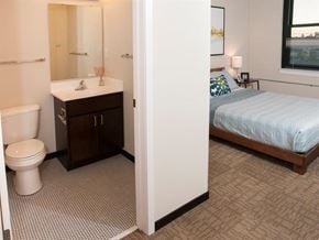 St Paul apartment for rent - A bathroom with a toilet, sink, and a bedroom with a bed.