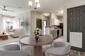 Pensacola apartment for rent - A modern dining room with a round table and grey chairs.