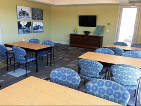 Dallas apartment for rent - A room with tables and chairs and a television on the wall.