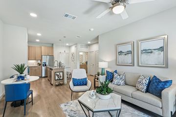 Bryan apartment for rent - A modern living room with a blue chair and a white couch.