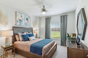 Bryan apartment for rent - A bedroom with a large bed and a ceiling fan.