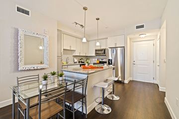Pembroke Pines apartment for rent - A kitchen with a glass table and bar stools.