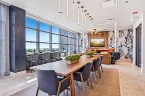 Chicago apartment for rent - a dining room with a long table and chairs and a wall of windows