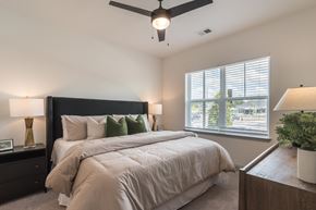 Charlotte apartment for rent - A bedroom with a large bed and a ceiling fan.