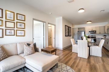 Charlotte apartment for rent - A living room with a white couch and a kitchen in the background.