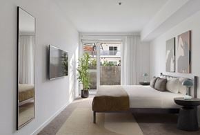 Glendale apartment for rent - A bedroom with a large bed and a large mirror on the wall.