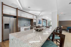 Ft Lauderdale apartment for rent - a kitchen with a large island with granite counter tops and a stainless steel refrigerator