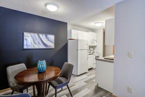 St. Louis Park apartment for rent - a dining room with a table and chairs and a kitchen with a refrigerator