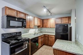 St. Louis Park apartment for rent - an empty kitchen with wooden cabinets and black appliances