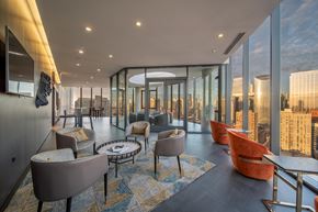 Chicago apartment for rent - A modern living room with a view of the cityscape outside the large windows.