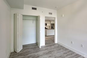 Plantation apartment for rent - a bedroom and a living room with white walls and wood flooring