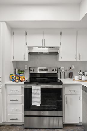 Clearwater apartment for rent - a kitchen with white cabinets and a black stove