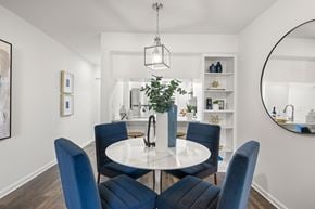 Clearwater apartment for rent - a dining room with blue chairs and a white table with a vase of flowers