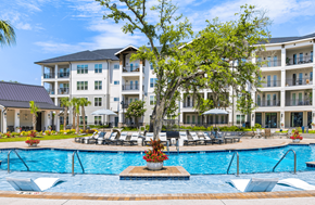 Charleston apartment for rent - A large white building with a pool in front.