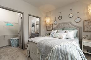 Pooler apartment for rent - A bedroom with a large bed and a mirror on the wall.