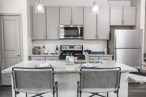 Pooler apartment for rent - A kitchen with a granite countertop and grey chairs.